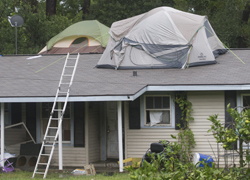 A pair of tents are set up on top of a house in Dickinson, Texas, Monday, Aug. 28, 2017, as floodwaters from Tropical Storm Harvey rise. (Stuart Villanueva/The Galveston County Daily News via AP)
